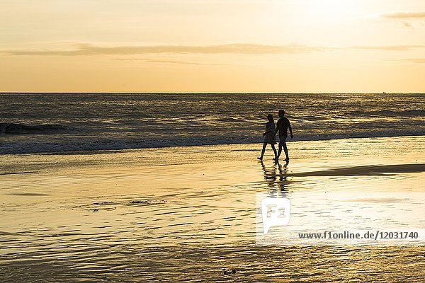 Paar  Mann und Frau  Spaziergang am Strand  Sonnenuntergang  Playa Espadilla  Nationalpark Manuel Antonio  Costa Rica  Mittelamerika