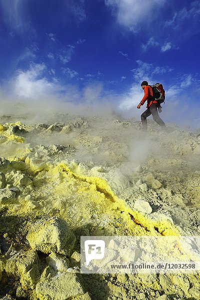 Hiker on the Gran Cratere walks through sulphur fumaroles  Vulcano Island  Liparic Islands  Italy  Europe