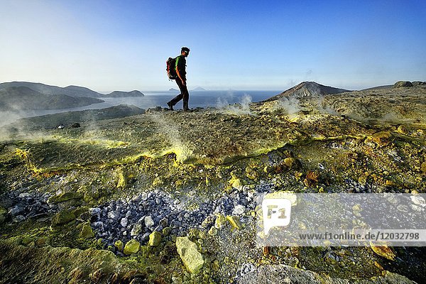 Hiker on the Gran Cratere walks through sulphur fumaroles  Vulcano Island  Liparic Islands  Italy  Europe
