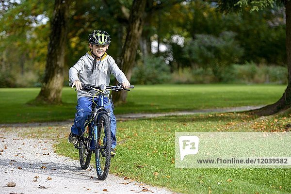 Boy  Child with helmet while riding a bike  Bavaria  Bavaria  Germany  Europe