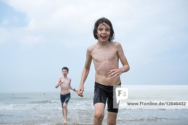 Kinder laufen vom Meer zum Strand  Nordsee  Knokke-Heist  Vlaanderen  Belgien  Europa