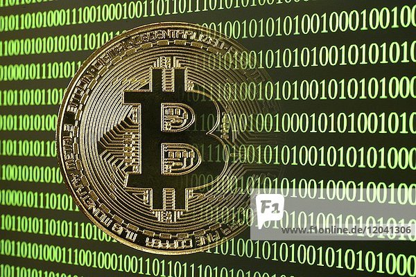 Symbolbild digitale Währung  goldene physische Münze Bitcoin verschwindet im digitalem Binärcode