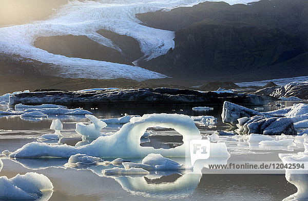 Ice arch among icebergs floating on Fjallsarlon lagoon near Jokulsarlon South Iceland Polar Regions