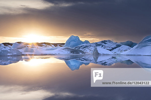 Eisberge mit Schneestaub bedeckt im Winter bei Sonnenuntergang  Jokulsarlon Gletscherlagune  Südisland  Polarregionen