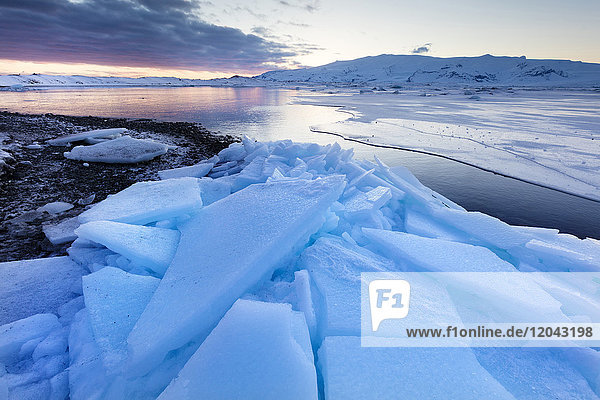Sunset over frozen Jokulsarlon Glacial Lagoon in winter South Iceland Polar Regions