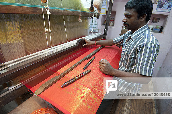 Seidenweber an seinem Webstuhl in seinem Haus  webt den begehrten rot-goldenen Kanchipuram-Seidensari  Kanchipuram  Tamil Nadu  Indien  Asien