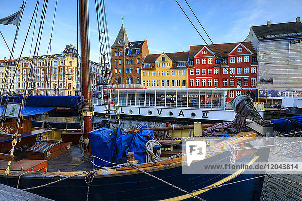 Boats in Christianshavn Canal with typical colourful houses in the background  Copenhagen  Denmark  Europe