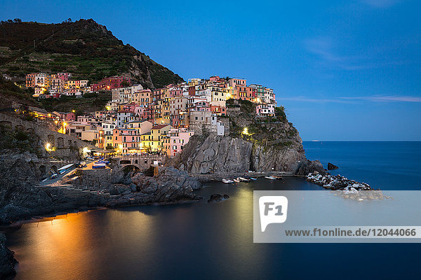 Eine Langzeitbelichtung zur blauen Stunde  als die Lichter in der farbenfrohen Stadt Manarola angehen  Cinque Terre  UNESCO-Weltkulturerbe  Ligurien  Italien  Europa