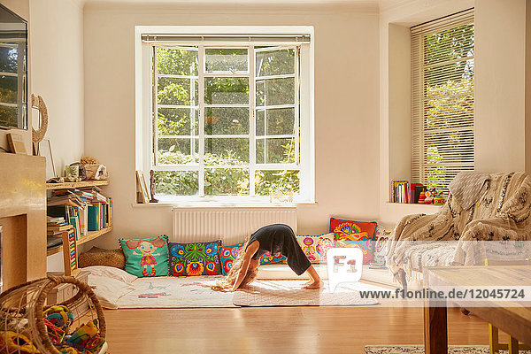 Young girl at home  bent over in yoga position