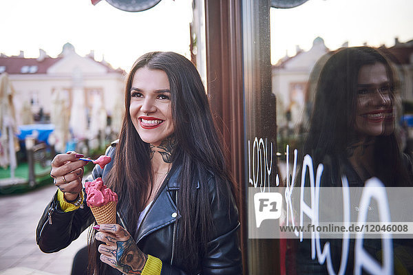 Porträt einer jungen Frau  die Eis isst  Tätowierungen auf der Hand