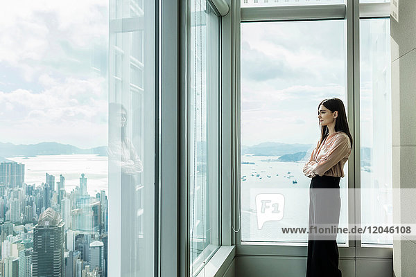 Geschäftsfrau schaut aus dem Fenster auf das Stadtbild