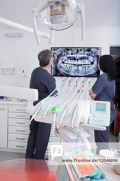 Zahnarzt und Zahnarzthelferin schauen auf den Scan