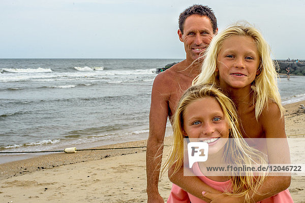 Portrait of mature man with blond haired son and daughter on beach  Asbury Park  New Jersey  USA