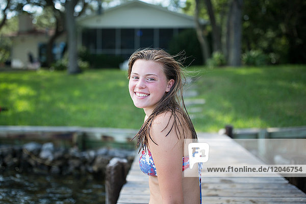 Portrait of teenage girl on jetty  smiling