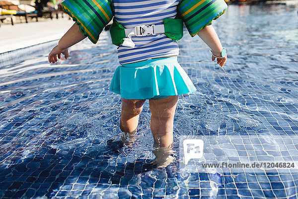 Junges Mädchen geht im flachen Wasser im Freibad  Rückansicht  niedriger Schnitt
