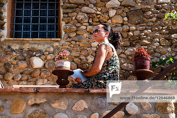 Reife Frau  die von der Terrassenmauer hinaussieht  Begur  Katalonien  Spanien