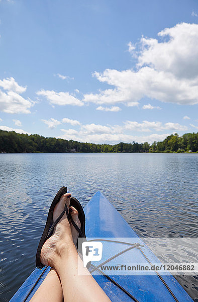 Woman relaxing on canoe  on lake  low section