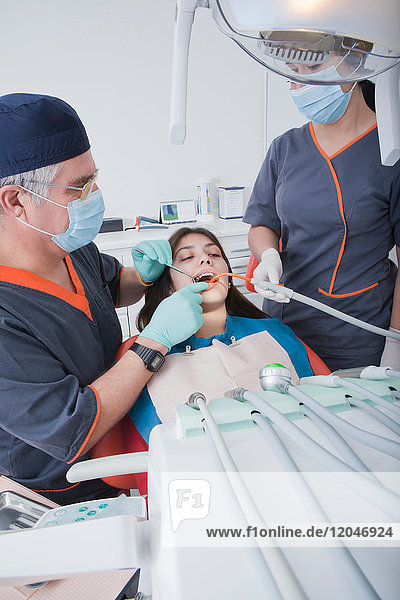 Zahnarzt und Zahnarzthelferin mit Patient
