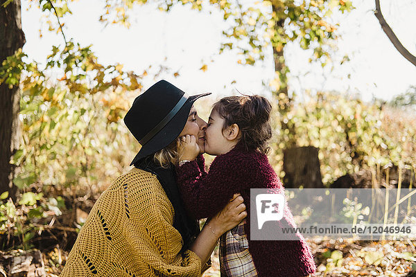 Mutter küsst und umarmt Tochter