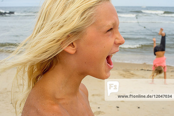 Boy with long blond hair and open mouth on beach  Asbury Park  New Jersey  USA