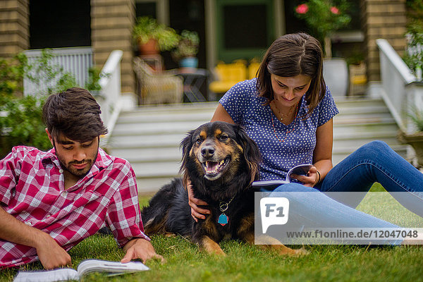 Pärchen auf der Wiese im Garten mit Hund  Lesung