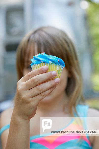 Young girl holding cupcake