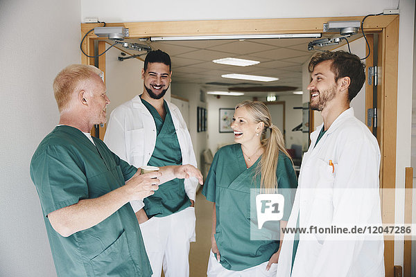 Cheerful medical colleagues talking in hospital corridor