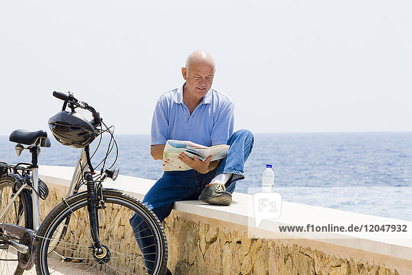 Man with Bicycle and Map by Water