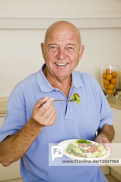 Porträt eines Mannes  der Salat isst