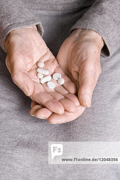 Elderly Woman Holding Pills