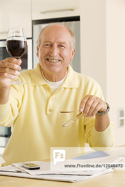 Porträt eines Mannes  der ein Glas Wein hebt