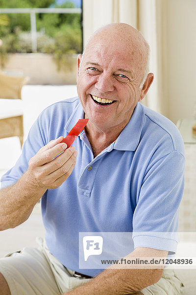 Porträt eines Mannes  der rote Paprika isst
