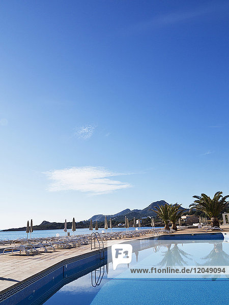 Sonnenliegen und geschlossene Sonnenschirme auf der Terrasse am Pool des Hotels  Cala Ratjada  Mallorca  Balearen  Spanien