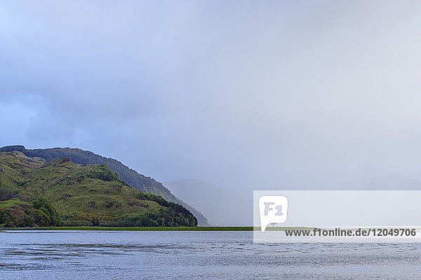 Neblige Wolken und ein einsamer Baum an der schottischen Küste in der Nähe von Eilean Donan Castle und Kyle of Lochalsh in Schottland  Vereinigtes Königreich