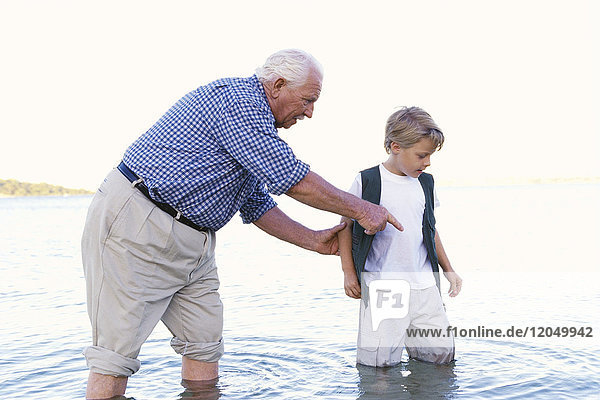 Großvater und Enkel waten im Wasser