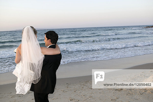 Groom Carrying Bride on Beach  Noosa Beach  Australia