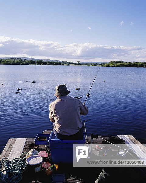 Mann beim Fischen am Dock  Hafen von Drumshanbo  Lough Allen  Leitrim  Irland