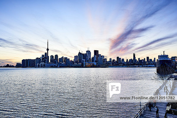 Touristen auf einem Boardwalk mit Blick auf die Skyline der Innenstadt in der Abenddämmerung; Toronto  Ontario  Kanada