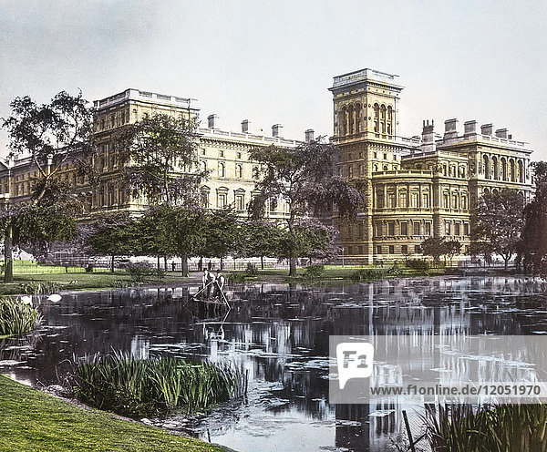 Diapositiv mit Laterna Magica um 1900  handkolorierte Ansichten von London  England in der viktorianischen Zeit. Regierungsgebäude vom St. James Park mit Teich davor. Wartungsarbeiter reinigen den Teich