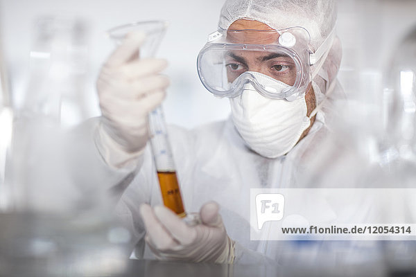 Scientist working in lab holding a cylinder