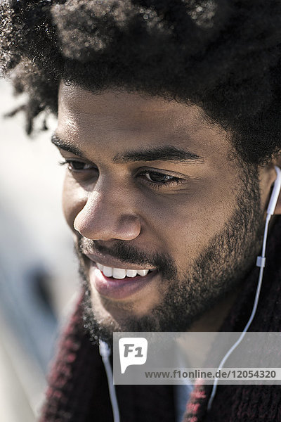 Portrait of smiling man listening to music on his earphones