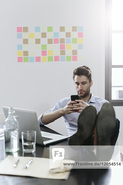 Young businessman working in office  using smartphone