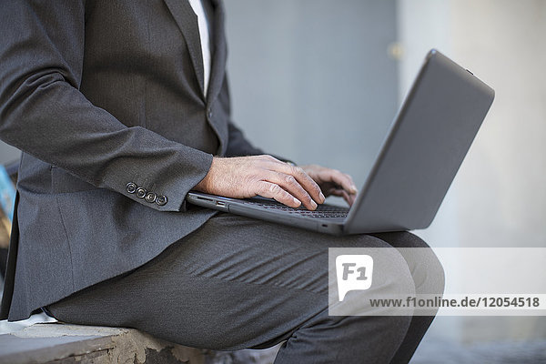 Businessman working on laptop outside