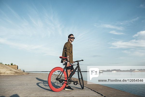 Young man with fixie bike at the waterfront