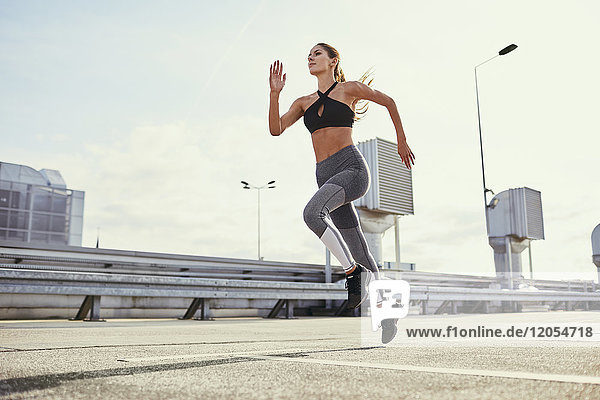 Young woman doing running exercises in the city