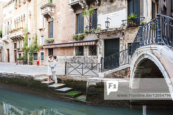 Italien  Venedig  Brautpaar auf einer Treppe am Kanal stehend