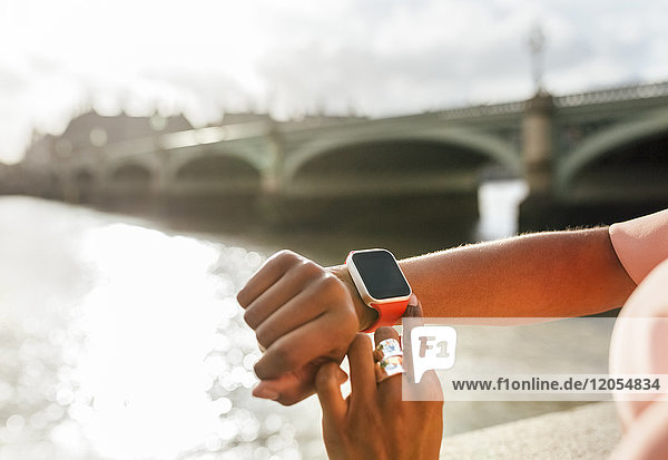 UK  London  close-up of woman using her smartwatch near Westminster Bridge