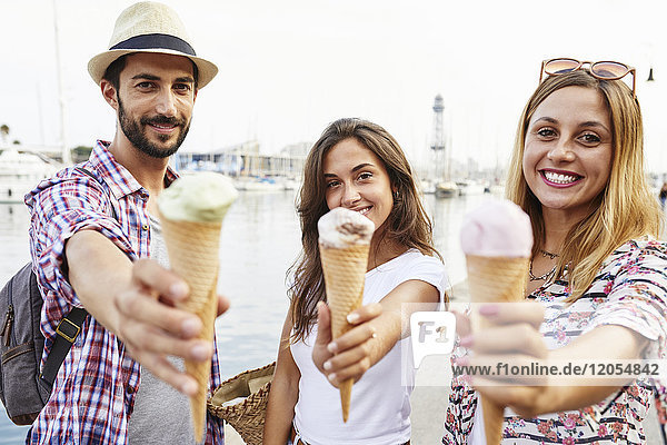 Three smiling friends holding ice cream cones