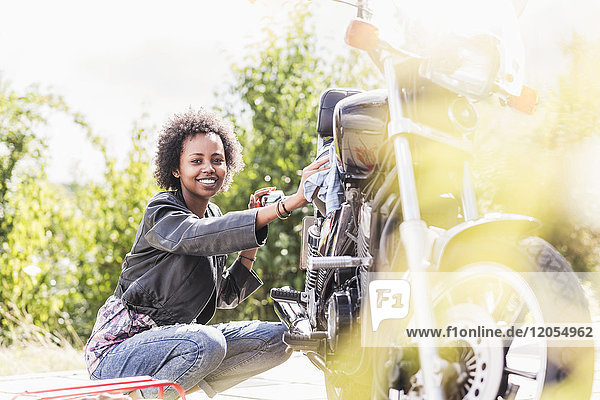 Junge Frau reinigt ihr Motorrad