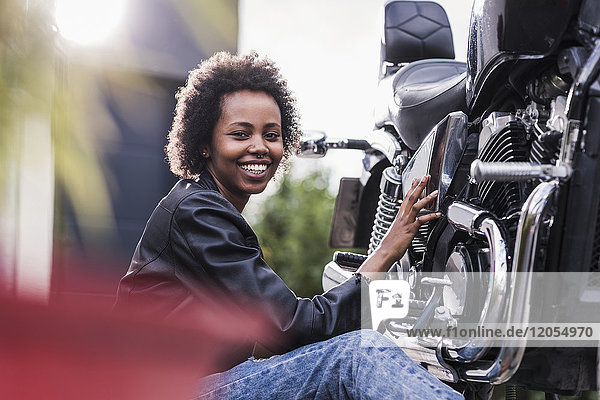 Young woman maintaining her motorcycle